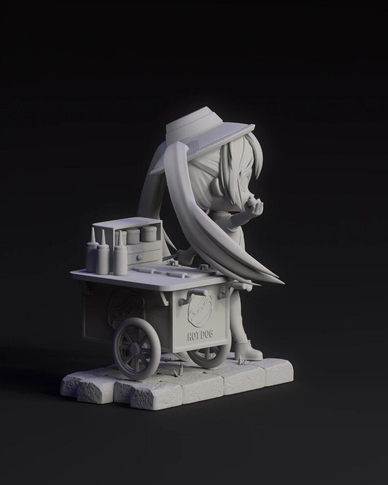 May include: A 3D-printed figurine of a character in a hat and boots, leaning against a hot dog cart. The cart has wheels, condiment bottles, and the words "HOT DOG" on the side. The figurine is on a stone base.