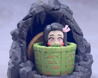 May include: A figurine of a character from the anime series Demon Slayer. The figure features a character with black hair and pink eyes, wearing a pink bow, inside a green basket. The basket is set inside a gray stone structure.