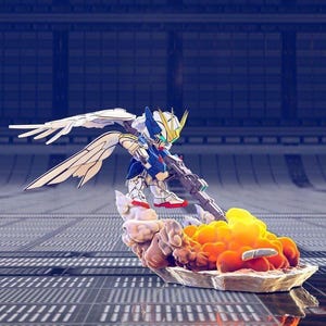 May include: A detailed action figure of a Gundam robot, featuring white, blue, and gold armor, holding a rifle. The figure is posed on a base with stylized cloud and flame effects, set against a futuristic backdrop.