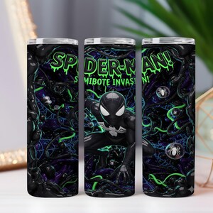 May include: Three stainless steel tumblers with a Spider-Man theme. The design features the text "Spider-Man! Symbiote Invasion!" in green, a black and white Spider-Man figure, and a dark background with green and purple accents.