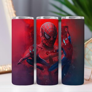 May include: Three stainless steel tumblers with a Spider-Man design. The tumblers feature a red and blue colour scheme with images of Spider-Man in action. The background is a gradient of red and purple.