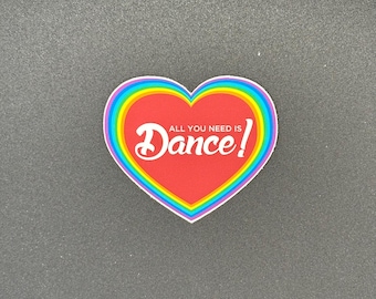 May include: A heart-shaped sticker with a red center and a rainbow border. The sticker has the words "All you need is Dance!" in white script.