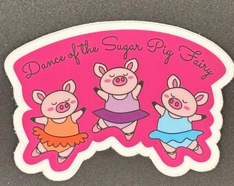 May include: A sticker featuring three cartoon pigs in ballet poses, each wearing a tutu in orange, purple, and blue. The sticker has a pink background with the text "Dance of the Sugar Pig Fairy" in cursive.