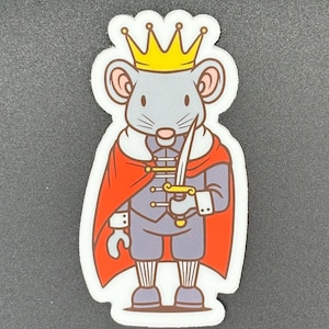 May include: A sticker featuring a cartoon mouse wearing a gold crown and a red cape. The mouse is holding a gold sword and is dressed in a gray suit with gray shorts and striped socks. The sticker has a white border.