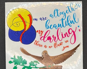May include: A square sticker with the text "You are altogether beautiful my darling; there is no flaw in you." The sticker features a bird with outstretched wings, a branch with green leaves, and abstract shapes in yellow, blue, and red.