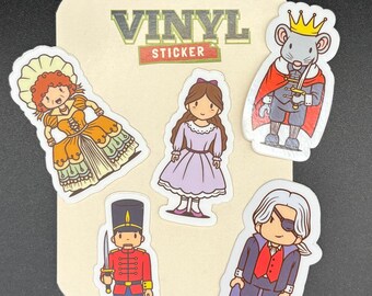 May include: A collection of vinyl stickers featuring cartoon characters from a story. The stickers include a princess in a purple dress, a soldier, a mouse king, and a man with an eyepatch. The stickers are on a beige background with the words "VINYL STICKER".