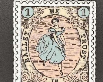 May include: A sticker in the shape of a postage stamp featuring a ballerina in a blue dress. The stamp design includes the text "BALLET IN WE TRUST" and the number "1" in two corners. The background is a mix of pink and beige.