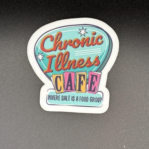 May include: A sticker with the words "Chronic Illness CAFE" in red and teal, with the text "WHERE SALT IS A FOOD GROUP". The sticker has a white border and a retro design.