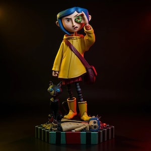 May include: A figurine of a girl with blue hair wearing a yellow raincoat, boots, and a red dress, holding a green button eye. A black cat and a doll are at her feet. The figurine is on a striped base.