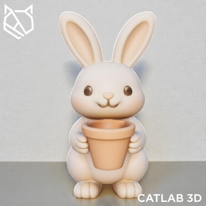 May include: A cream-colored bunny figurine holding a small, peach-colored flower pot. The bunny has large ears, a small nose, and brown eyes. The text "CATLAB 3D" is at the bottom.