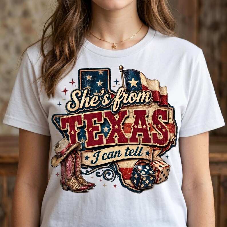 May include: White t-shirt featuring a graphic design with the text "She's from TEXAS I can tell". The design includes a Texas outline, a flag, cowboy boots, a hat, and dice.