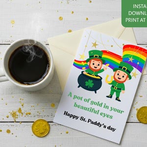 Może przedstawiać: Kartka z okazji Dnia Świętego Patryka z dwoma skrzatami, garnkiem złota i tęczą. Na kartce widnieje napis "A pot of gold in your beautiful eyes Happy St. Paddy's day". Na zdjęciu widoczny jest również kubek kawy i złote monety.