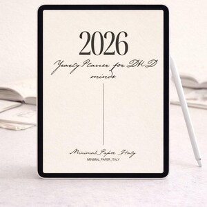 May include: A digital tablet showing a 2026 yearly planner. The screen displays the text "2026", "Yearly Planner for DH D minds", and "Minimal Paper Italy". A white stylus is positioned to the right of the tablet.