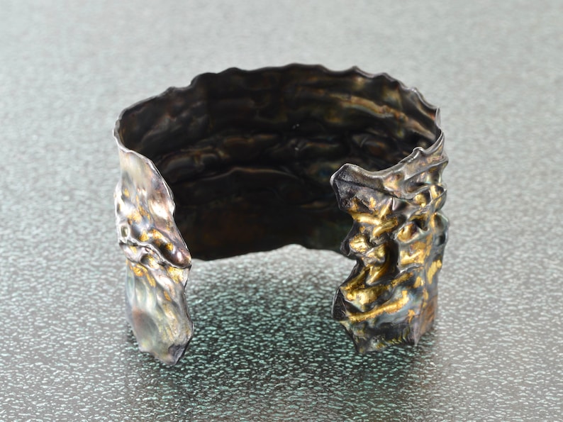 Artistic fold-formed hammered silver-and-gold cuff bracelet.