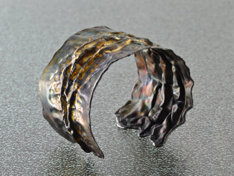 Artistic fold-formed hammered silver-and-gold cuff bracelet.