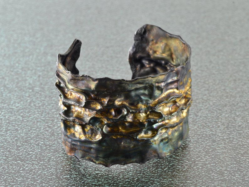Artistic fold-formed hammered silver-and-gold cuff bracelet.