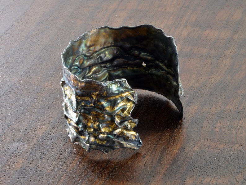 Artistic fold-formed hammered silver-and-gold cuff bracelet.