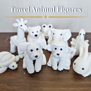 May include: A collection of white towel animal figures, including a giraffe, bear, frog, elephant, dog, monkey, turtle, swan, and rabbit. The figures are arranged on a brown surface. The text "Towel Animal Figures" is at the top.