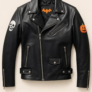 Puede incluir: Chaqueta de cuero negra estilo biker con un parche de calavera y un parche de calabaza. La chaqueta tiene un emblema de murciélago en el pecho. Cuenta con cremalleras y herrajes plateados. Una chaqueta elegante.