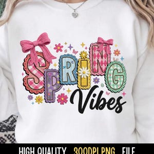 May include: White sweatshirt with the words "SPRING Vibes" in colorful, decorative letters. The letters are adorned with bows, flowers, and patterns. The text "HIGH QUALITY . 300DPI PNG . FILE" is at the bottom.