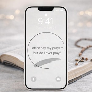 May include: A smartphone displaying a lock screen with the time 9:41 and the date Tuesday, April 24. The screen features the text "I often say my prayers but do I ever pray?" in a circular design. A rosary and an open book are in the background.