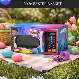 以下が含まれることがあります： 青、赤、紫のデザインのコミック風電子レンジで、「KABOOM！」と「BAM！」の文字と12:00の時刻が表示されています。 電子レンジは2026年のイースターバスケットの一部です。