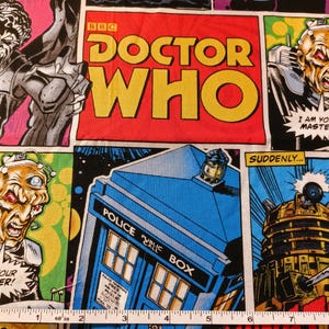 May include: A fabric panel featuring comic book style illustrations with the words "Doctor Who" in large yellow letters on a red background. The panel includes images of the TARDIS, Daleks, and other characters, with speech bubbles and the word "Exterminate".
