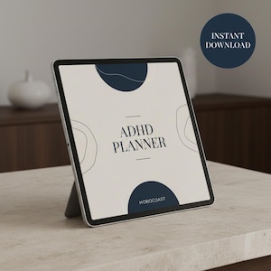 May include: A digital tablet showing an ADHD planner design. The screen displays the text "ADHD PLANNER" in a minimalist font, with navy blue abstract shapes. The word "MOROCOAST" is at the bottom. A navy blue circle with "INSTANT DOWNLOAD" is in the upper right corner.