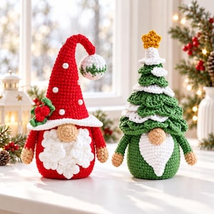 Könnte beinhalten: Zwei gehäkelte Figuren: ein roter Wichtel mit hoher Mütze, weißem Bart und Perlenakzenten sowie ein grüner Wichtel, der von einem gehäkelten Weihnachtsbaum mit gelbem Stern gekrönt wird. Beide haben eine beigefarbene Nase und eine Textur aus Garn.