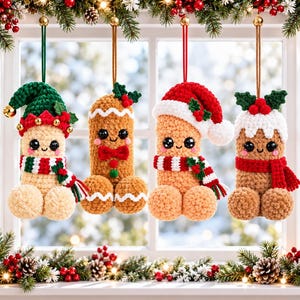 Puede incluir: Cuatro adornos de ganchillo colgados de cuerdas. El primero es un elfo con gorro verde y bufanda a rayas. El segundo es una figura de pan de jengibre con pajarita roja. El tercero lleva un gorro de Papá Noel rojo y bufanda. El cuarto es un pudin.