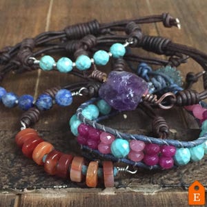 K&ouml;nnte beinhalten: Ein Set aus f&uuml;nf Lederarmb&auml;ndern mit verschiedenen Edelsteinperlen. Die Armb&auml;nder haben T&uuml;rkis-, Amethyst-, Karneol- und Lapislazuli-Perlen. Das Leder ist braun und die Perlen sind auf silbernem Draht aufgef&auml;delt.