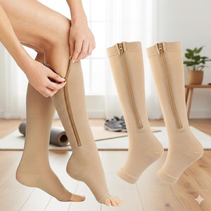 May include: Beige compression socks with a full-length zip. The socks extend from the foot to just below the knee. One sock is being zipped up, while two others are displayed separately. The socks are designed to provide support and improve circulation.