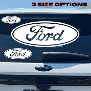 May include: Three white oval Ford logo decals applied to the rear window of a white vehicle. The text 3 SIZE OPTIONS is displayed in red at the top. The decals feature the black Ford script inside a white oval with a black border outline.