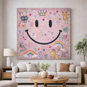 Könnte beinhalten: Ein großes quadratisches Leinwandgemälde mit hellrosa Hintergrund und einem markanten schwarzen Smiley-Gesicht. Das Kunstwerk ist mit bunten, handgezeichneten Kritzeleien verziert, darunter Regenbögen, Kronen, Herzen und verschiedene kleine Kreaturen.