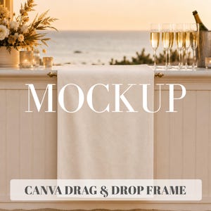 May include: A plain, off-white rectangular towel hanging over a horizontal bar. The image features the text MOCKUP in large white letters and CANVA DRAG & DROP FRAME in smaller dark gray text at the bottom, set against a coastal outdoor scene.