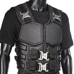Op de afbeelding: Zwart tactisch vest met meerdere zakken en zilveren gespen. Het vest heeft een gewatteerd ontwerp en een ritssluiting aan de voorkant. De schouderbanden hebben zilveren gespen met rode stiksels. Het vest wordt getoond op een zwarte mannequin.