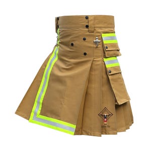 Puede incluir: Una falda escocesa utilitaria de color tostado con tiras reflectantes de color amarillo neón de alta visibilidad, múltiples bolsillos cargo con cierres a presión, un gancho de metal plateado y un logo negro con el texto "kilts fit".