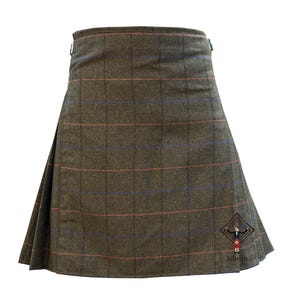 May include: A brown kilt with a plaid pattern featuring red and blue lines. The kilt has a pleated design and metal hardware. The bottom right corner has a logo with the text "kilt fit".
