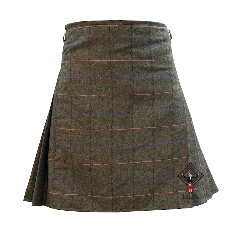 May include: A brown kilt with a plaid pattern featuring red and blue lines. The kilt has a pleated design and metal hardware. The bottom right corner has a logo with the text "kilt fit".
