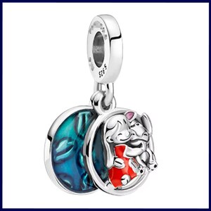 May include: A silver charm with a dangling design. One side has a blue and green swirl pattern, and the other shows a cartoon character in a red outfit hugging an elephant-like creature. The charm is marked with "S925".