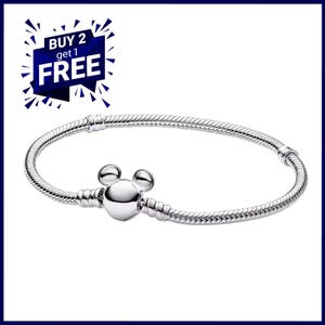 K&ouml;nnte beinhalten: Ein silberfarbenes Armband mit einem Mickey-Mouse-f&ouml;rmigen Verschluss. Das Armband hat ein Schlangenketten-Design. Das Bild enth&auml;lt auch eine blau-wei&szlig;e Grafik mit der Aufschrift "BUY 2 get 1 FREE".
