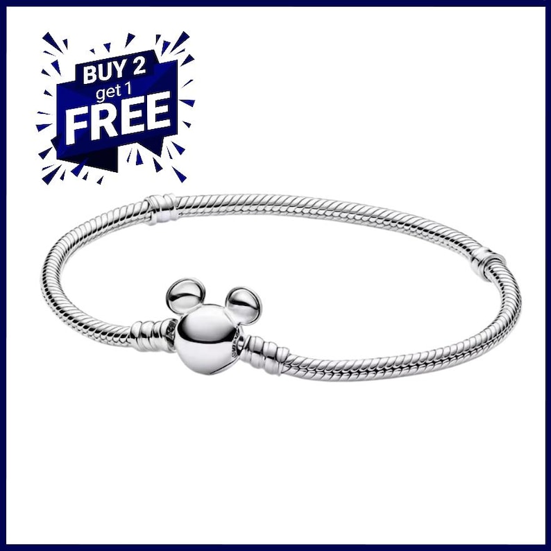 K&ouml;nnte beinhalten: Ein silberfarbenes Armband mit einem Mickey-Mouse-f&ouml;rmigen Verschluss. Das Armband hat ein Schlangenketten-Design. Das Bild enth&auml;lt auch eine blau-wei&szlig;e Grafik mit der Aufschrift "BUY 2 get 1 FREE".