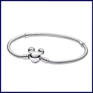 K&ouml;nnte beinhalten: Ein silbernes Armband mit einem Mickey-Mouse-Anh&auml;nger. Das Armband hat ein Schlangenketten-Design und einen runden Verschluss. Der Anh&auml;nger ist ein polierter, dreidimensionaler Mickey-Mouse-Kopf. Es ist ein Schmuckst&uuml;ck.