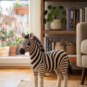 May include: A white ceramic mug with a black handle and the text "But First, Coffee" in a black, handwritten-style font. The mug is on a white surface.