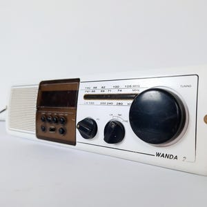 May include: A white ceramic mug with a black handle and the text "But First, Coffee" in a black, bold font. The mug is likely for hot beverages.