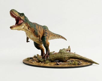 Op de afbeelding: Gedetailleerd beeldje van een Tyrannosaurus Rex met open mond, staand over een gevallen dinosaurus. De T-Rex is geschilderd in tinten groen, bruin en bruin, met een gedetailleerde textuur. De basis is een cirkelvormig platform met droog gras.