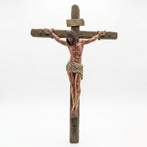Könnte beinhalten: Ein Holzkreuz mit einer Skulptur von Jesus Christus. Die Figur ist mit einer Dornenkrone, Wunden und einem Lendenschurz dargestellt. Das Kreuz besteht aus verwittertem Holz mit einer kleinen Tafel oben.