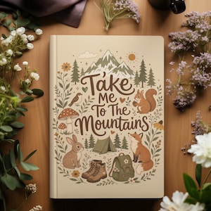 May include: A beige journal featuring the text "Take Me To The Mountains" and illustrations of a mountain range, animals, and camping equipment. The journal is surrounded by flowers and a coffee cup.