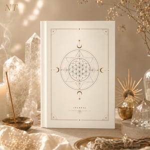 May include: A white hardcover journal featuring a gold-toned geometric design on the front cover. The central graphic displays a flower of life pattern enclosed within a star and circular frame, with moon phases and the word JOURNAL printed below.