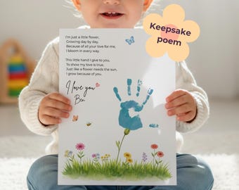 Op de afbeelding: Een kind houdt een aandenken gedicht print vast. De print bevat een blauwe handafdruk, een bloemillustratie en de tekst "I'm just a little flower...I grow because of you. I love you Ben." Een bloemvormige afbeelding leest "Keepsake poem."